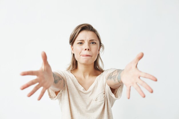 Giovane ragazza graziosa divertente che allunga le mani alla macchina fotografica.