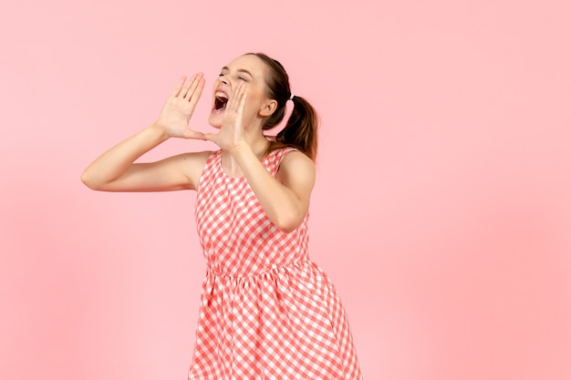 giovane ragazza in abito luminoso carino chiamando ad alta voce qualcuno in rosa