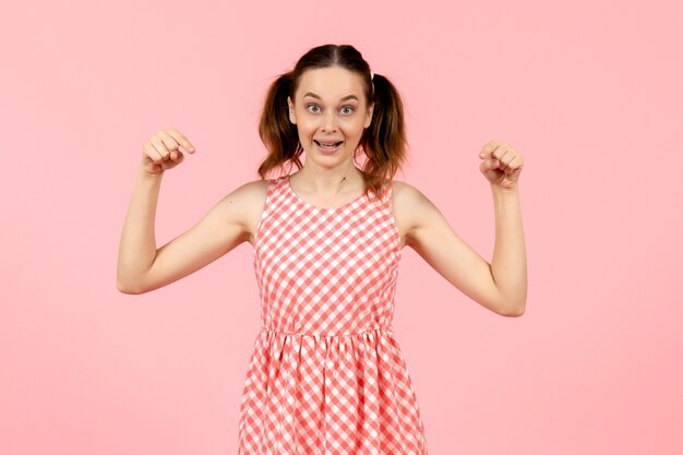 giovane ragazza in abito rosa carino che punta sul rosa