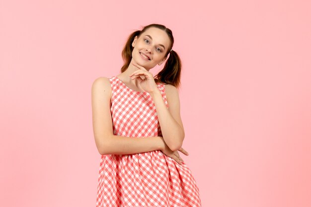 giovane ragazza in abito rosa carino con volto sorridente in rosa