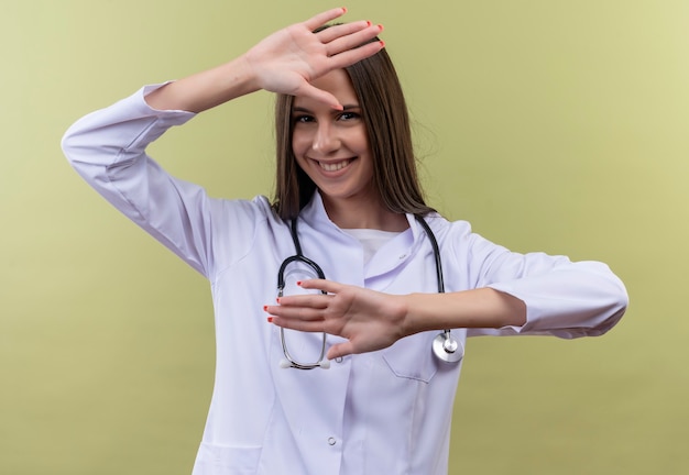 Giovane ragazza medico indossa abito medico stetoscopio - sulla parete verde