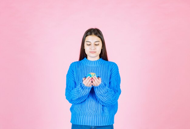 giovane ragazza modello guardando una piccola palla di terra.