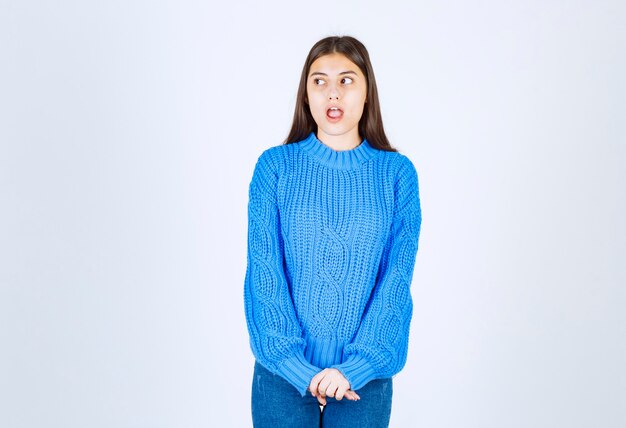 giovane ragazza modello in piedi e in posa su bianco-grigio.