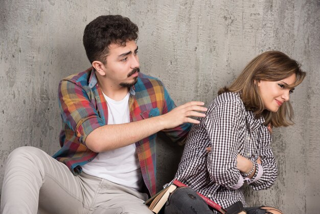 Giovane ragazza offesa dall'uomo circondato da libri