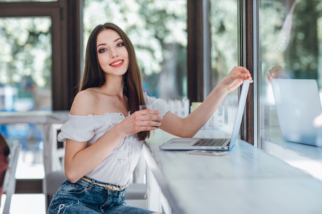 Giovane ragazza sorridente con un bicchiere in mano