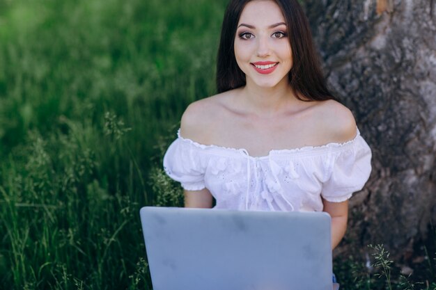 Giovane ragazza sorridente con un computer portatile