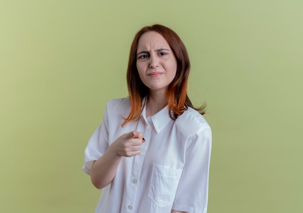 Giovane ragazza spiacevole della testarossa che ti mostra il gesto su verde oliva