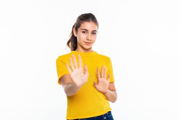 Giovane ragazza teenager seria nel fanale di arresto di fabbricazione casuale sulla parete bianca