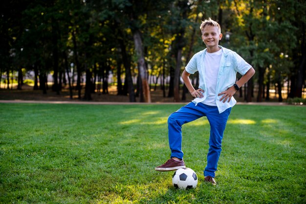 Giovane ragazzo all'aperto con la palla di calcio