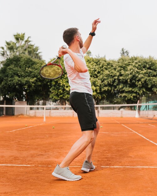 Giovane ragazzo atletico che gioca a tennis