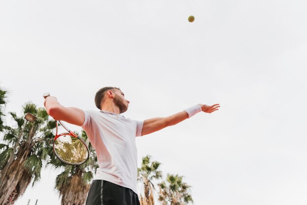 Giovane ragazzo atletico che gioca a tennis