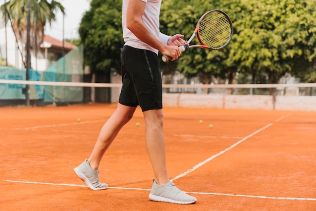 Giovane ragazzo atletico che gioca a tennis