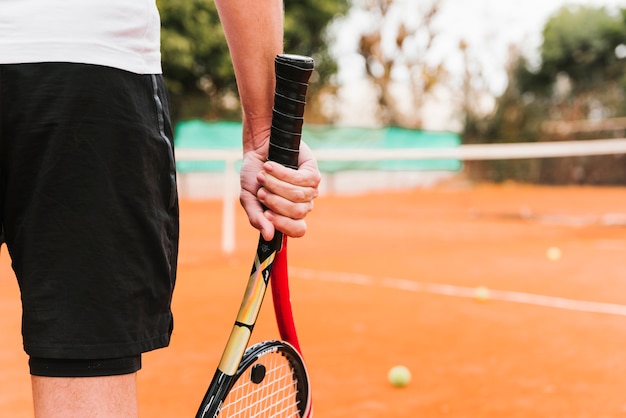 Giovane ragazzo atletico che gioca a tennis