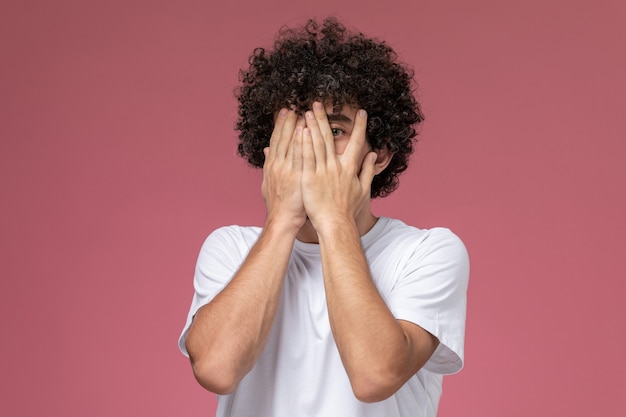 giovane ragazzo che copre il viso con le mani oltre l'occhio sinistro