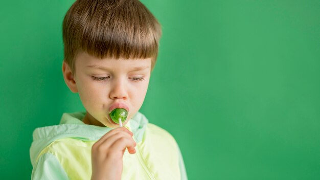 Giovane ragazzo che mangia lecca-lecca