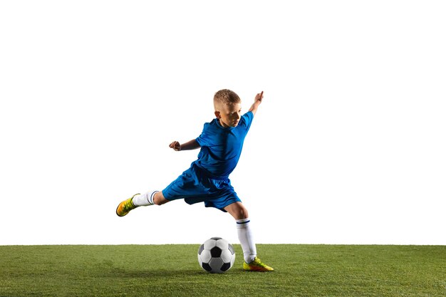 Giovane ragazzo come un giocatore di calcio o di calcio in abbigliamento sportivo che fa una finta o un calcio con la palla per un obiettivo su sfondo bianco studio. Ragazzo che gioca in forma in azione, movimento, movimento durante il gioco.