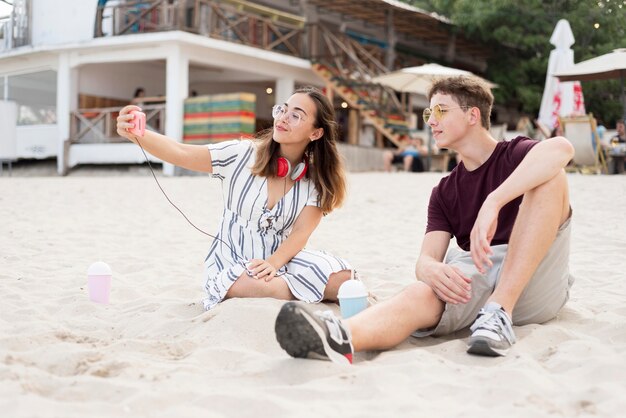 Giovane ragazzo e ragazza che si distendono insieme alla spiaggia