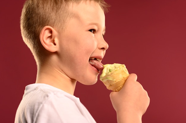 Giovane ragazzo felice che mangia il gelato