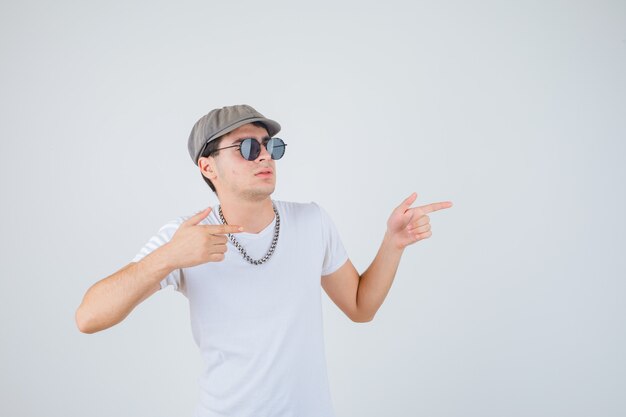 Giovane ragazzo in t-shirt, cappello rivolto da parte e guardando sicuro di sé, vista frontale.