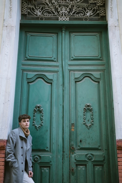 Giovane ragazzo vicino a una grande porta d'ingresso