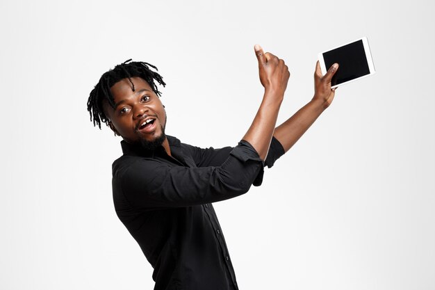 Giovane riuscito uomo d'affari africano che fa selfie sul bianco.