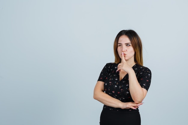 Giovane signora bionda in vestito che gesturing isolato