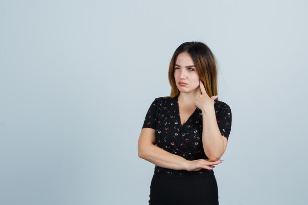 Giovane signora bionda in vestito che gesturing isolato