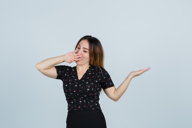 Giovane signora bionda in vestito che gesturing isolato