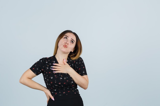 Giovane signora bionda in vestito che gesturing isolato