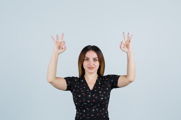 Giovane signora bionda in vestito che gesturing isolato