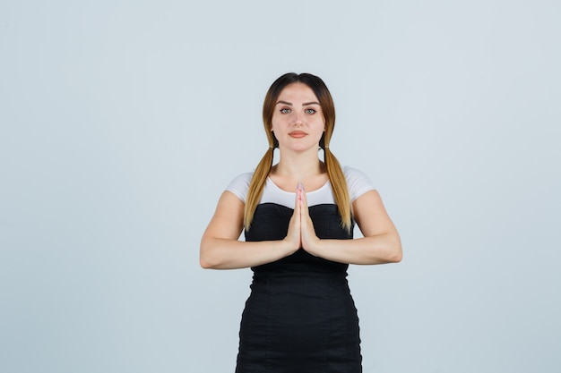 Giovane signora bionda in vestito che gesturing isolato