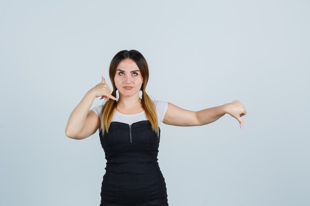 Giovane signora bionda in vestito che gesturing isolato