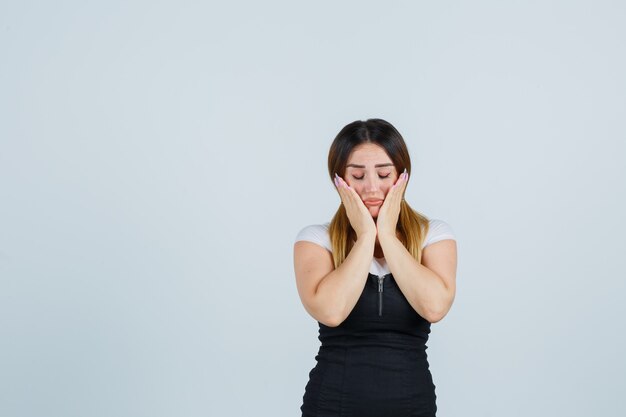 Giovane signora bionda in vestito che gesturing isolato