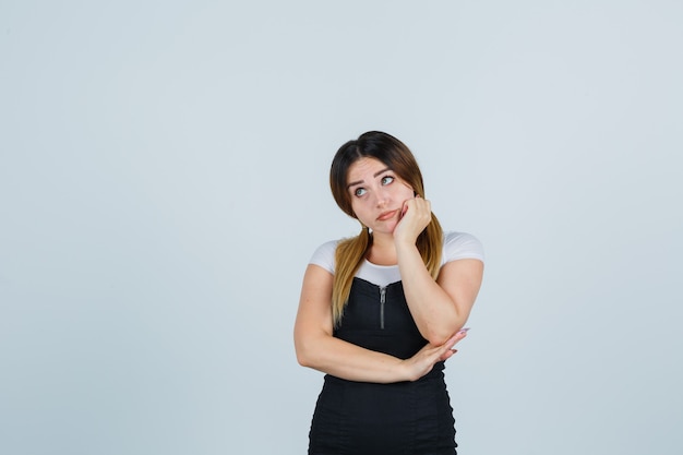 Giovane signora bionda in vestito che gesturing isolato