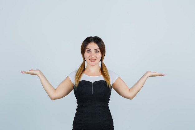 Giovane signora bionda in vestito che gesturing isolato