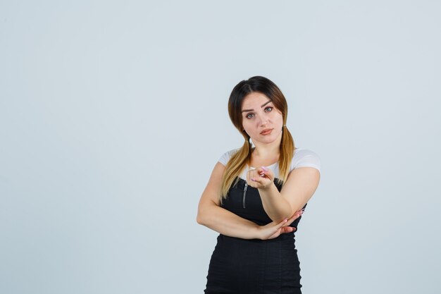 Giovane signora bionda in vestito che gesturing isolato