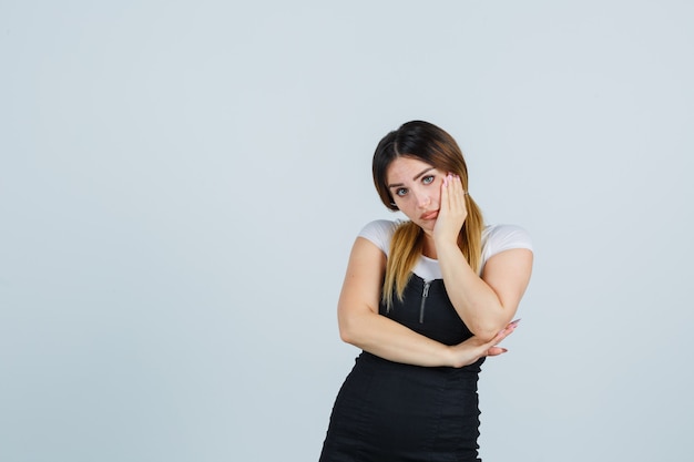 Giovane signora bionda in vestito che gesturing isolato