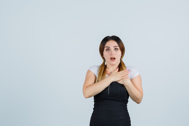 Giovane signora bionda in vestito che gesturing isolato