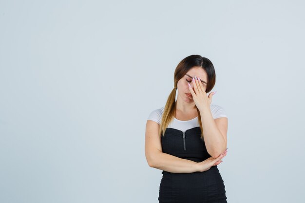 Giovane signora bionda in vestito che gesturing isolato