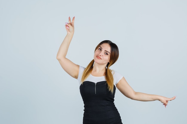 Giovane signora bionda in vestito che gesturing isolato