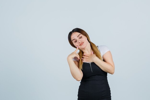 Giovane signora bionda in vestito che gesturing isolato