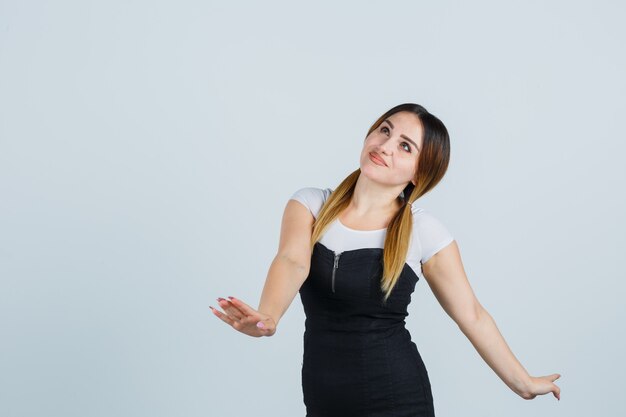 Giovane signora bionda in vestito che gesturing isolato