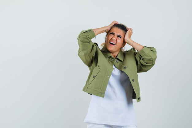 Giovane signora che strappa i capelli in pantaloncini della giacca di t-shirt e sembra ansiosa