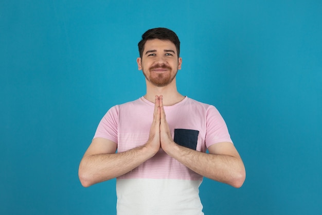 Giovane sorridente che fa meditazione su un azzurro.