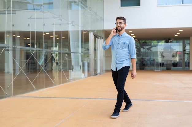 Giovane sorridente che parla dal telefono cellulare