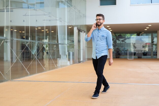 Giovane sorridente che parla dal telefono cellulare