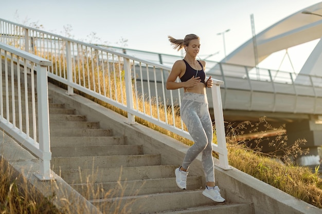 Giovane sportiva che corre giù per le scale all'aperto