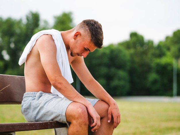 Giovane sportivo attraente che si rilassa dopo l'allenamento - concetto di allenamento