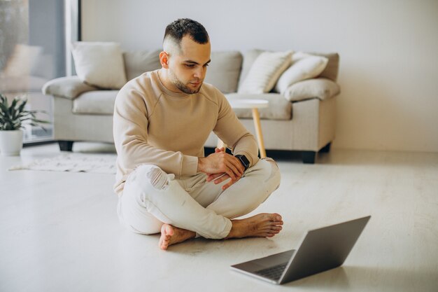 Giovane sportivo che pratica yoga a casa