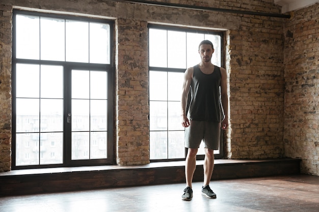 Giovane sportivo concentrato e riposo in palestra